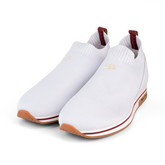 White slip-on sneakers with brown soles on a white background